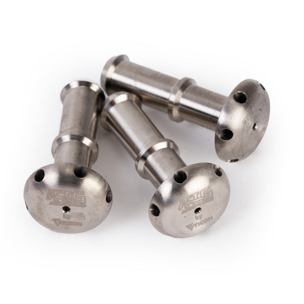 Three pieces of raw titanium shower head diffusers on their side with precision CNC machined outlet ports, displayed against a white background with TIG Aesthetics and Ticon logo laser etched on the bottom.