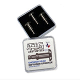 Three titanium shower head diffusers inside a black box with a clear lid, labeled as 'Shower Head Diffuser Upgrade Quick Disconnect' by TIG Aesthetics.